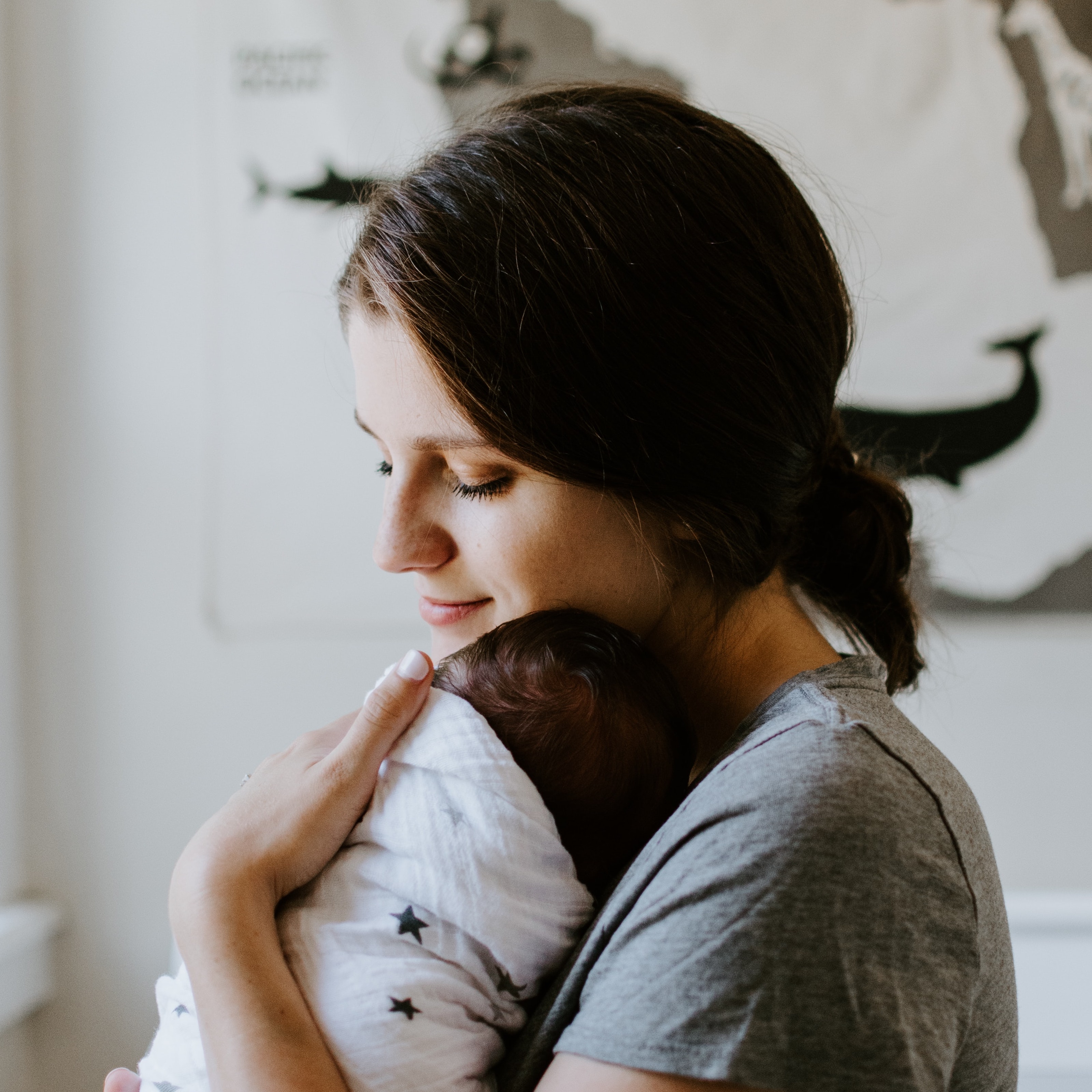 mother holding swaddled baby